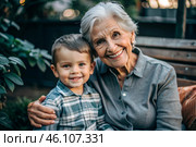 A happy family, a child and a grandmother hug on the street in the park, happy and contented. A grandmother who hugs her grandson, showing love. Стоковое AI-изображение, AI-художник Photojuli / Фотобанк Лори
