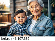 A happy family, a child and a grandmother hug on the street in the park, happy and contented. A grandmother who hugs her grandson, showing love. Стоковое AI-изображение, AI-художник Photojuli / Фотобанк Лори