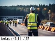 Supervisor wearing hard hat and safety vest overseeing road construction project. Стоковое AI-изображение, AI-художник Иван Рябоконь / Фотобанк Лори