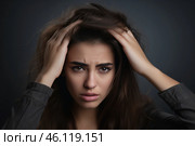 A young woman in a dark setting touches her forehead, expressing sadness and fatigue possibly after a long, exhausting day. Стоковое AI-изображение, AI-художник Sergey Grishin / Фотобанк Лори