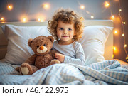 A cute curly-haired girl hugs a teddy bear, sitting in a cozy bed, a small child hugs a toy and gets ready for bed. A healthy night's sleep. Стоковое AI-изображение, AI-художник Photojuli / Фотобанк Лори