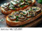Two slices of bread with fried mushrooms and herbs, probably parsley, on top. The mushrooms are sliced ​​thin and carefully placed on the toasted crust. The bread looks fresh and soft, and the mushrooms glisten from the oil they were cooked in. You can see green herbs around the mushrooms, which add freshness and contrast to the brown mushrooms and golden crust of the bread. It's a delicious moment, creating a home-cooked, rustic feel. Стоковое AI-изображение, AI-художник Анна Кривицкая / Фотобанк Лори