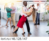 Woman dances incendiary tango with African man partner during choreography lesson. Стоковое фото, фотограф Яков Филимонов / Фотобанк Лори