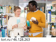 During shopping, African male client with wife advised and choose shampoo, shower gel, bast wisp. Стоковое фото, фотограф Яков Филимонов / Фотобанк Лори