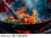 Vibrant vegetables sizzling in a hot skillet over an outdoor flame during a lively cooking session. Стоковое AI-изображение, AI-художник Sergey Grishin / Фотобанк Лори