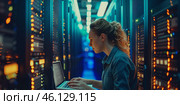 Female IT technician works diligently in a data center while managing network configurations in a busy environment. Стоковое AI-изображение, AI-художник Sergey Grishin / Фотобанк Лори