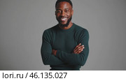 Confident professional posing with folded arms on gray background. Стоковое видео, видеограф Данил Руденко / Фотобанк Лори