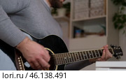 Playing the guitar. Strumming acoustic guitar. Musician plays music. Man fingers holding mediator. Man hand playing guitar neck in dark room. Unrecognizable person rehearsing, fretboard close-up. Стоковое видео, видеограф Марина Демидюк / Фотобанк Лори