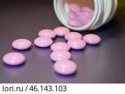 Здравоохранение и медицина. Таблетки рассыпаны из тубы на черном фоне. Стоковое фото, фотограф Дмитрий Сакретарев / Фотобанк Лори