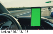 Navigator with green screen in the car dashboard. GPS module. Driver using smart phone with green background. Man steering wheel, driving on highway with smartphone navigation. Digital display monitor. Стоковое AI-видео, аниматор Марина Демидюк / Фотобанк Лори