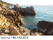 Waves gently crash against the rugged rocks while the sun sets over the horizon. Experience the serene beauty of this coastal location filled with natural wonders. Canj, Montenegro, Adriatic sea (2024 год). Стоковое фото, фотограф Юлия Петровская / Фотобанк Лори