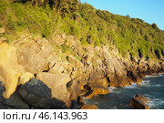 Waves gently crash against the rugged rocks while the sun sets over the horizon. Experience the serene beauty of this coastal location filled with natural wonders. Canj, Montenegro, Adriatic sea (2024 год). Стоковое фото, фотограф Юлия Петровская / Фотобанк Лори