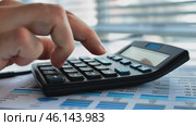 Man pressing calculator close up. Desk with diagram, graph, finance. Investment, accounting, calculating tax, corporate financial company report. Person checking bills, bank account balance, expenses. Стоковое AI-видео, аниматор Марина Демидюк / Фотобанк Лори