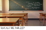 Modern classrooms interior with desks and green blackboard. Empty Classroom setup with school furniture and a chalkboard. No people. Nobody. Blurry view of class room with chairs and tables in campus. Стоковое AI-видео, аниматор Марина Демидюк / Фотобанк Лори