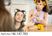 Two women curl their hair with curlers and use patches. Стоковое фото, фотограф Яков Филимонов / Фотобанк Лори