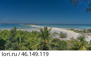 Beautiful tropical postcard landscape. A winding sandbar in the aquamarine ocean. A green island in the distance. Boats at sea. Lush vegetation in the foreground. The blue sky. Madagascar. Nosy Iranja. Стоковое фото, фотограф Вера Ивановна Кубарева / Фотобанк Лори