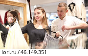 Man with wife participate in inspection of goods, help determine choice of skirt. Стоковое видео, видеограф Яков Филимонов / Фотобанк Лори