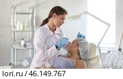 Professional female aesthetician administering hardware procedure on young woman using ion bubble attachment of hydrogen oxygen machine to cleansing and moisturizing face skin. Стоковое видео, видеограф Яков Филимонов / Фотобанк Лори
