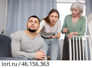 Man dont speaking after discord with mother and wife standing behind. Стоковое фото, фотограф Яков Филимонов / Фотобанк Лори