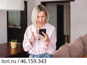 middle-aged woman holding phone, reading unpleasant news in social media. Стоковое фото, фотограф Гладских Татьяна / Фотобанк Лори
