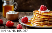 Delicious pancakes with honey, blueberries, raspberries and . The concept of the Russian holiday Maslenitsa. Стоковое AI-изображение, AI-художник Photojuli / Фотобанк Лори