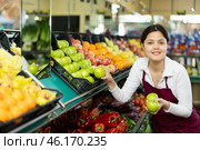 Asian female seller in apron chooses juicy apple. Стоковое фото, фотограф Яков Филимонов / Фотобанк Лори