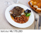 Baked pork cheek with stewed pinto beans and greens. Стоковое фото, фотограф Яков Филимонов / Фотобанк Лори