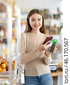 Female buyer checks suitability - scans QR code on seasonings herbs label in grocery store. Стоковое фото, фотограф Яков Филимонов / Фотобанк Лори
