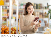 Female buyer checks suitability - scans QR code on seasonings herbs label in grocery store. Стоковое фото, фотограф Яков Филимонов / Фотобанк Лори