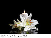 Funeral lily flowers and burning candle on dark background. Стоковое фото, фотограф Pixel_shot / Фотобанк Лори