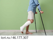 Young man with broken leg near color wall. Стоковое фото, фотограф Pixel_shot / Фотобанк Лори