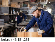 Male furniture assembler assembles wooden table at furniture factory. Стоковое фото, фотограф Яков Филимонов / Фотобанк Лори