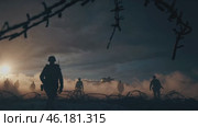 Soldiers advancing on battlefield at sunset behind barbed wire. Стоковое видео, видеограф Данил Руденко / Фотобанк Лори