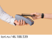 Buyer paying for purchase via terminal on color background. Стоковое фото, фотограф Pixel_shot / Фотобанк Лори