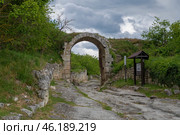 Вид на старинные ворота Орта-Капу (Северные ворота)  крепости Чуфут-Кале облачным майским днем. Крым (2024 год). Стоковое фото, фотограф Виктор Карасев / Фотобанк Лори