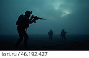 Silhouettes of military soldiers maneuver through thick fog, preparing for an active confrontation. Atmosphere is tense as the sun begins to rise. The military goes on the night attack. Generative AI. Стоковое AI-изображение, AI-художник Юлия Петровская / Фотобанк Лори