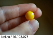Yellow ball balanced on a fingertip against a dark background during daylight. Стоковое AI-изображение, AI-художник Юлия Гапеенко / Фотобанк Лори
