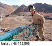 Газосварщик, на ремонтном участке по обслуживанию тяжелой дизельной техники в горной местности Якутии, на золотодобывающем участке ( Оймяконский район ) (2009 год). Редакционное фото, фотограф Павел Просянов / Фотобанк Лори