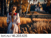 A girl in a traditional Russian linen sundress and with a braid on her head in a field of ripe golden wheat against a background of birch trees and an Orthodox church. Harvesting. Стоковое AI-изображение, AI-художник Photojuli / Фотобанк Лори