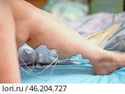 Electrodes of a muscle stimulator placed on the calf muscle to enhance muscle tone and strength, showcasing modern technology in physical therapy and fitness. Стоковое фото, фотограф Татьяна Степанищева / Фотобанк Лори