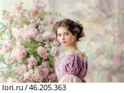 Прекрасная юная девушка у чудесноого цветущего розового куста, ретро стиль. Стоковое AI-изображение, AI-художник Щеголева Ольга / Фотобанк Лори