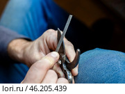 A man sharpens the blade of a garden pruner with a file. Garden tools. Стоковое фото, фотограф Коханова Наталья / Фотобанк Лори