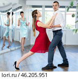 Woman in red and man in formal wear rehearsing tango in pair. Стоковое фото, фотограф Яков Филимонов / Фотобанк Лори