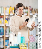 Man uses barcode to get information about glass cleaner spray in mobile application. Стоковое фото, фотограф Яков Филимонов / Фотобанк Лори