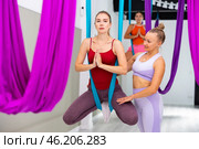 Woman practicing antigravity yoga with personal trainer. Стоковое фото, фотограф Яков Филимонов / Фотобанк Лори