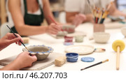 Girl hands paints bowl of clay during master class, close up. Стоковое видео, видеограф Яков Филимонов / Фотобанк Лори