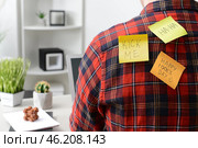 Sticky notes on back of young man working in office. April Fool's Day prank. Стоковое фото, фотограф Pixel_shot / Фотобанк Лори