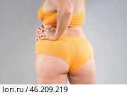 Overweight thigh, woman with fat hips, legs and buttocks, obesity female body with cellulite on gray background. Стоковое фото, фотограф Станислав Тарко / Фотобанк Лори