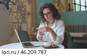 Business woman using mobile smart phone and online working on laptop computer, surfing the internet, searching the information at office. Female student online studying from home, e-learning concept. Стоковое видео, видеограф Ирина Михайличенко / Фотобанк Лори
