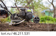 Man farmer working in field ploughing the land with a plough on a farm. Ploughman on a walk behind motor cultivator. Season processing soil in village. Organic cultivate natural products. Agriculture. Стоковое фото, фотограф Руслан Хисматов / Фотобанк Лори